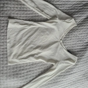 Vit ribbad tröja - Vit långärmad tröja av ribbat material i storlek S, men skulle även passa XS och M. Urringad både bak och fram och aldrig använd, endast testad. Mjuk och tunn så passar perfekt till sommaren!🦋