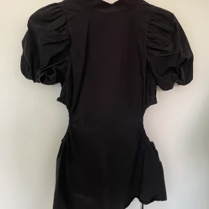 Svart blus - Svart blus med detalker som cut outs och puffärm från Gina tricot! Stl XS, pris 50kr