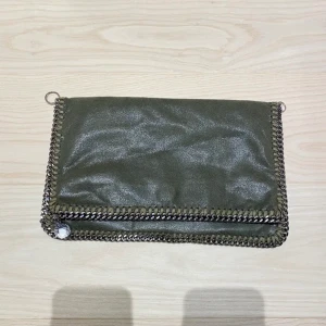 Stella McCartney Clutch  - Säljer min fina stella clutch bag, går att använda både som clutch men har även två öglor på sidorna som gör att den går att använda som vanlig väska också. Inköpt på vestiaire collective för 2500, år 2019. Kom med prisförslag!