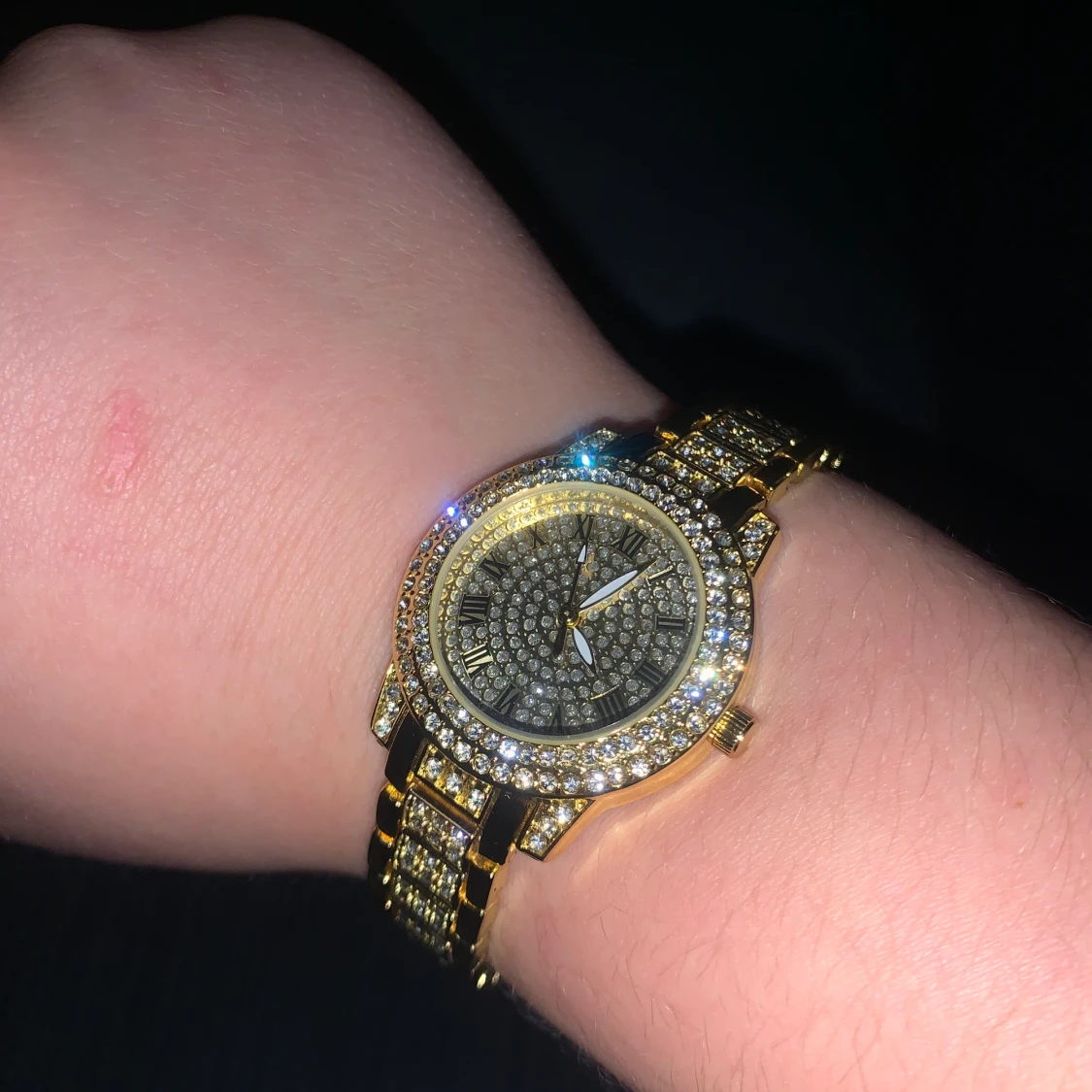 Klocka med glittrande stenar och guld