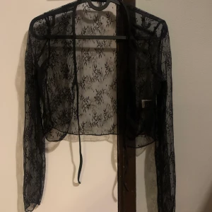 Svart genomskinlig kofta - En genomskinlig kofta. Kommer inte till användning då den har blivit för liten. 