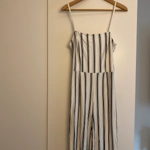 Jumpsuit Bershka M - Vitsvartrandig jumpsuit i trikåtyg. Jätteskön! Storlek M men passar mig som är storlek S.