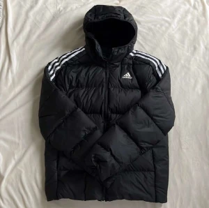 Adidas Jacka - Adidas jacka köpt för ungefär 1 år sen, har använts bara på en vinter. Fortfarande fin inga hål ser ganska ny ut 