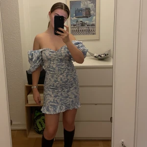 Blommig tight kortklänning med puffärmar - Ett av Ginas välkända plagg, använd vid ett tillfälle. Skitsnygg med ärmarna både uppe och nere! 