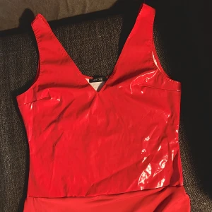 Lack body - En body från Nelly med lackmaterial. Aldrig använd då den var för liten. Strl M men skulle säga att den är lite liten i strl.