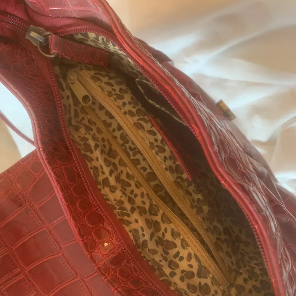 Säljer min röda handväska med leopard mönster på insidan. Säljer den då jag inte använder den! Frakten är 49kr! . Väskor.