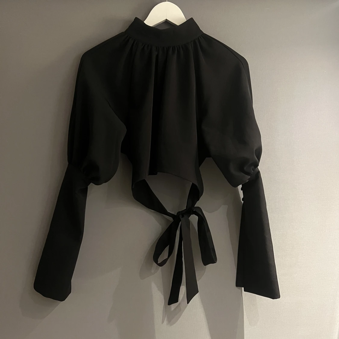 Svart tröja med snören att knyta i ryggen