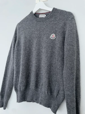 Stickad Moncler tröja - Stickad moncler tröja Storlek: M Skick: 8/10 Färg: grå Vårt pris: 1400kr Retail: 5000kr