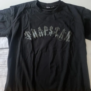 Trapstar T-shirt - Säljer en självklart äkta trapstar tshirt då den var för stor för mig. Den är lite oversized skulle jag säga i modellen.  10/10 skick då jag endast provat den, kommer i sin förp. Modellen heter Barbed Wire Arch Tee - Black Black Modellen känns oversized.