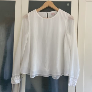 Fin vit blus! -  En väldigt fin blus med lite transparenta armar och en fin skurning baktill! Även söta spetsdraperi i ärmarna och dubbla lager nedtill. En av mina favoritblusar som tyvärr blivit för liten<3  Köparen står för frakt, men kan även mötas i Göteborg! 