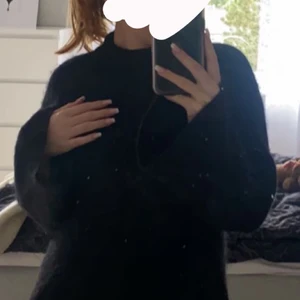 Svart stickad, utsvängda armar  - Svart stickad tröja med utsvängda armar. 