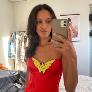 Röd wonderwoman korsett  - Skitsnygg wonderwoman korsett perfekt för halloween👻 Storlek medium från början men insydd för att passa mig som normalt är en s eller xs. Har en liten fläck som syns på bild två. 