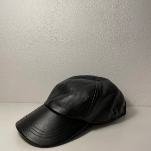 Skinnkeps  - Svart keps i skinn, så cool! Använd men i felfritt skick. 