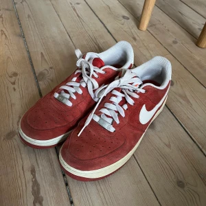 Nike Air Force 1 röda strl 40 - Säljer ett par jättefina Airforce 1!! Köpta på Depop men passar tyvärr inte mig, storlek 40 och kommer med låda:) säljs för 900 elr till högstbjudande!