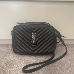 YSL väska - Nu är det dags för mig att sälja min fina YSL camera bag. Den har använts en hel del och det är därför priset är såpass lågt. Jag har kvar tillhörande dustbag och toffs. Skriv till mig privat om frågor finns!💗