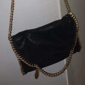 Svart väska  - Säljer en jättefin svart väska med guld kedja och leopard mönster innuti. De är även glitter i tyget. Har tyvär aldrig kommit till användning 