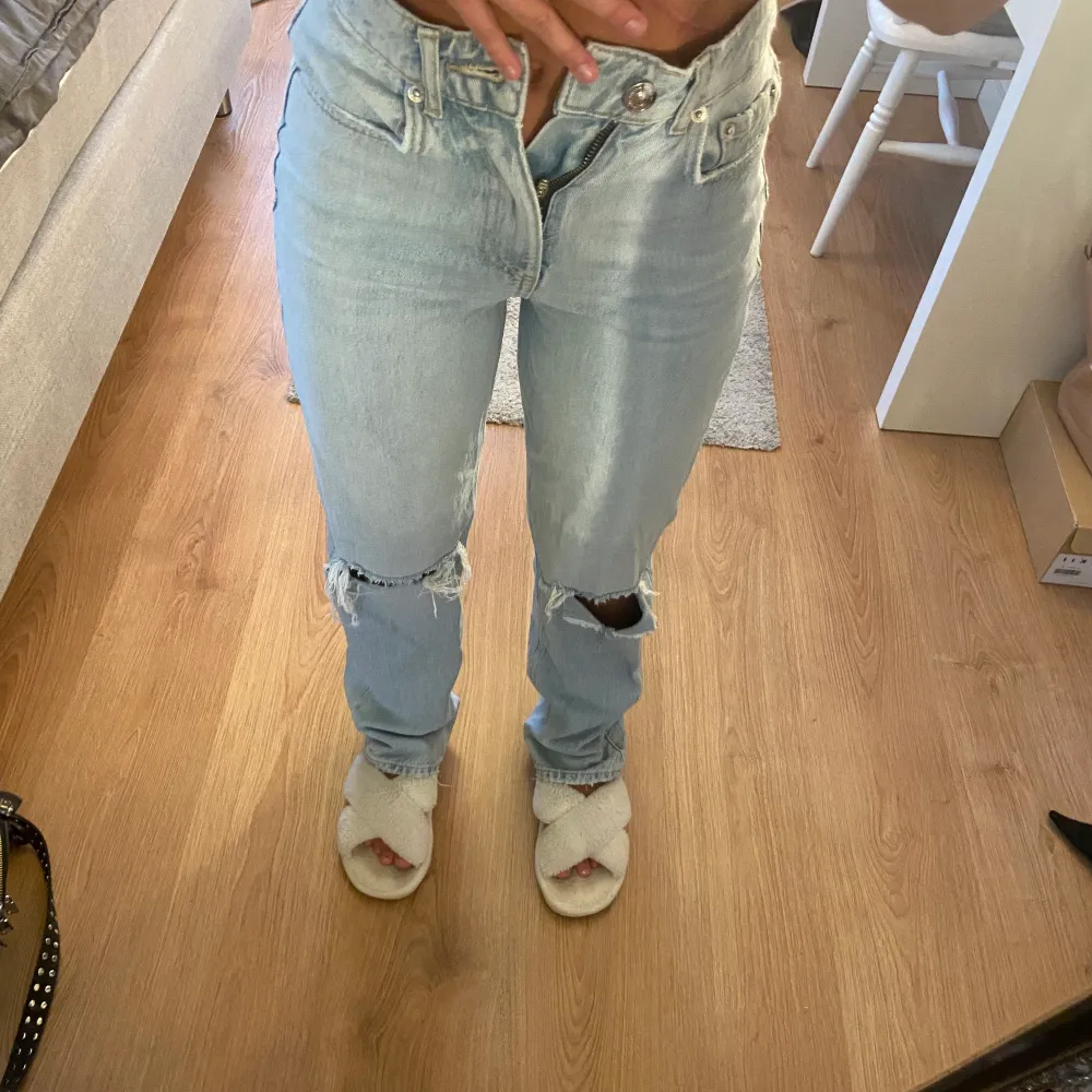 Ett par blåa jeans med hål från Gina som har blivit för små. Passar bra i längden på mig som är 160cm lång. Köpare står för frakt❣️. Jeans & Byxor.
