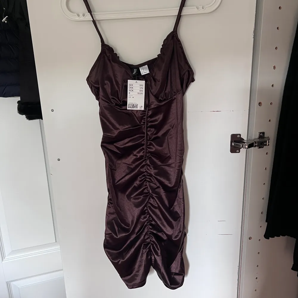 En brun klänning från H&M i storlek M. Aldrig använd, endast testad, lapp finns kvar. Klänningar.