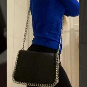 Tiamo väska - Så fin trendig svart väska från Tiamo med snygga kedje ditalier. Inga tydliga difekter men är använd. Säljer väskan då jag tröttnat lite på den men är inget fel på den. Skriv för fler bilder. Köparen står för frakten som alltid!❤️ vid stort intresse startar jag budgivning:)