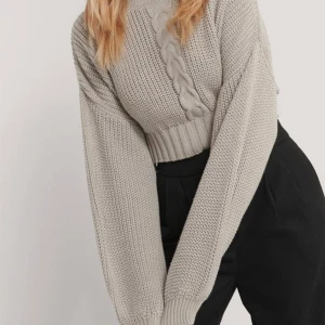 Stickad tröja NA-KD - En grå stickad tröja från NA-KD med croppad passform. Storlek M. Använd ett fåtal gånger! Frakt tillkommer📦