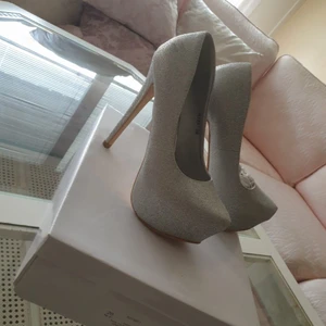 Festskor glittrande silver - Festskor i glittrande silver  Storlek: 36 Klackhöjd 14 cm Skick: minimal skada på klacken (syns ej vid användning ).  Nytt skick  Endast provade. Säljer på grund felköp  storlek  Nypris 400kr Säljes för Endast 100kr Hämtas i Brandbergen eller skickas på post mot portoavgift