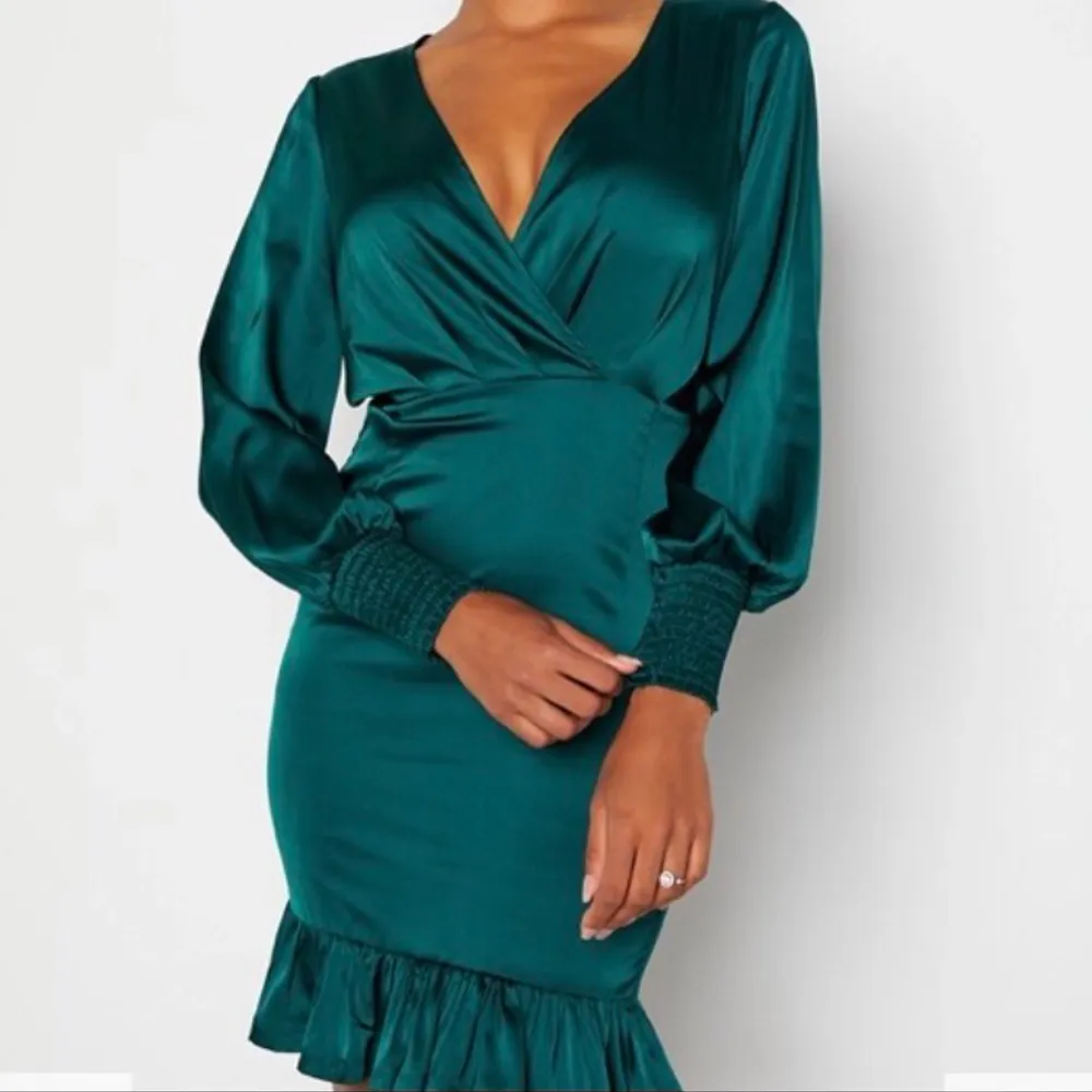 Grön satin klänning med volang nertill, V-ringad. Klänningar.