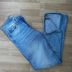 Ett par ljusblå jeans med slit från ginatricot i storlek 32