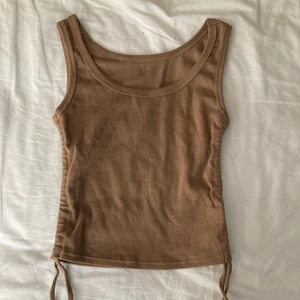 Brunt trendigt linne - Detta fina bruna linne köpte jag för ett tag sen, men det har inte kommit till användning. Den är oanvänd och justerbar på sidorna. Skriv till mig privat för fler bilder och vid intresse! Köparen står för frakten.