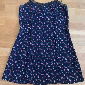 Blommig klänning  - Svart, blommig slipklänning från H&M. Storlek 38, banden är justerbara. Mycket bra skick.