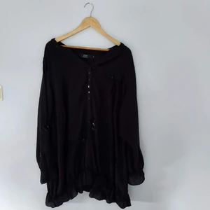 Blus med en ficka och paljetter - En lång blus med en liten ficka och dekorativa paljetter och broderi. Storlek XL 100% viskos.