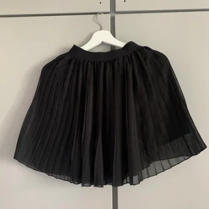 Svart plisserad kjol - Storlek 36, aldrig använd.