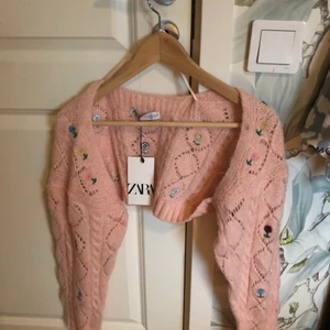 Kort kofta - Super gullig stickad kort ”kofta” från Zara! Är mestadels bara ärmar och har fina broderade blommor💕🌺 Säljer då det inte var min stil och missade återlämningsdatum, lapp hänger fortfarande kvar Nypris 259, köparen står för frakten