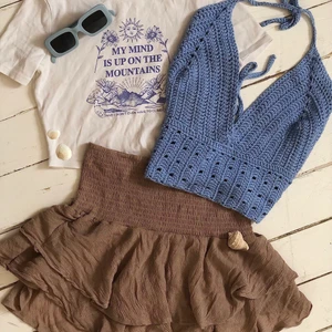 Kläd kit - Säljer dessa plagg i ett kit för 249kr. 💓 De som ingår är följande: T shirt med tryck  Virkad blå topp Brun beige volangkjol  Blåa solbrillor  ————————————— Allt är i storlek s/m Hör av dig vid intresse 🫶🏻  