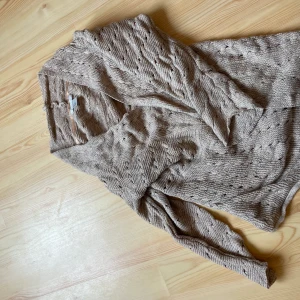 Stickad Kofta från HM - M - Stickad kofta från HM storlek M i fint skick. Koftan är i mörk beige färg. Säljes pga att jag inte använder den längre. Meddela om du är intresserad, tryck inte på köp dirket! Köparen står för frakten.