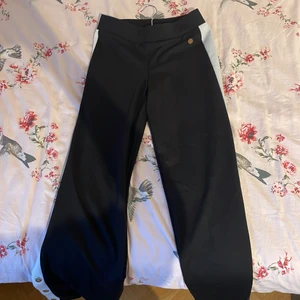 Ett par svarta byxor som är helt oanvända☺️ - Svarta byxor som är vida och har en vit rand på sidan🤍 Och längs ner är det knappar som man kan knäppa upp☺️ Storlek 158 och helt oanvänd!!