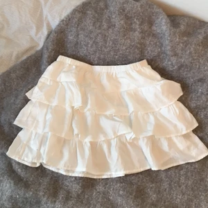 Vit volangkjol - Säljer denna jättefina volangkjolen i fint skick, storlek S men passar även xs och m då den har resår i midjan. Frakten kostar 39kr