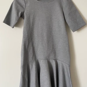 Grå klänning med volang  - Grå klänning med volang från Gina tricot. Storlek M. Stretch. 