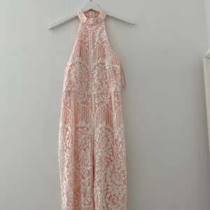 Jumpsuit - Helt ny jumpsuit i rosa med vit spets. Prislappen kvar.