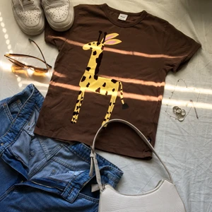 Babytee - Babytee i NYSKICK. Aldrig använd från tidigt 2000-tal. Chokladbrun färg och en söt giraff på som även har lite mjukare tyg på. Storleken är xxs/xs så toppen sitter tajt och croppad. ❤️