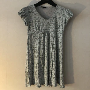 Kort blommig klänning - Jättefin men väldigt kort blommig klänning som jag säljer för att den inte kommer till användning. Jag har köpt den second hand och den är cool att ha till jeans eftersom att den är så kort, men om man är mindre än mig så funkar den som klänning också💗💗