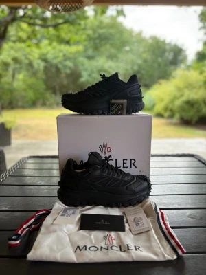 Moncler vinterskor - Säljer ett par riktigt snygga Moncler vinterskor! Nyskick förutom att jag har råkat förstöra boxen lite. Storlek 44, svarta, 10/10 skick. Säljer pågrund av fel köp av storlek. Skriv om du har några frågor!
