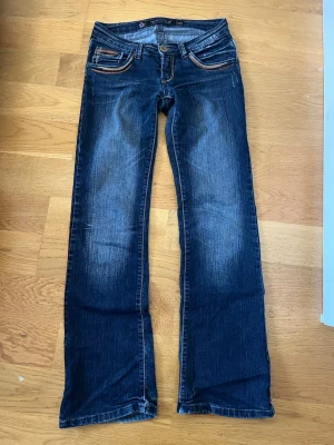 Mörkblå bootcut jeans med snygga sömmar  - Säljer dessa snygga vintage mörkblå bootcut jeans med coola sömmar och slitningar