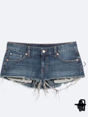 Lågmidjade jeansshorts med fransar - Snygga blå denimshorts med låg midja och råa, fransiga kanter. Klassisk femficksmodell med knapp och dragkedja framtill. Perfekta för sommaren och ger en avslappnad vibe. ORD PRIS 400 och knappt använda!