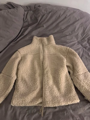 Beige teddyjacka med dragkedja - Mysig beige teddyjacka i pilematerial med hög krage och hel dragkedja framtill. Helt oanvänd från gina tricot lapp kvar. Nypris 500