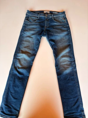 Blåa replay jeans - Tjena säljer nu ett par blåa jeans med lätt slitna detaljer och klassiska fickor. Jeansen har en medelhög midja och är gjorda i denim med stretch för extra komfort. Jeansen är köpta på NK i Göteborg. Har länge varit favvo jeansen men är tyvvär för små! Storlek W30 L32