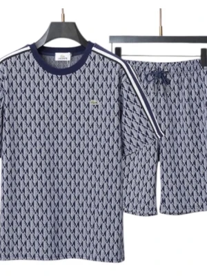  Lacoste - Snygg blå pyjamas från Lacoste med vitt geometriskt mönster och klassisk krokodillogga på bröstet. Setet har långärmad tröja med vita ränder på axlarna och matchande byxor med dragsko i midjan. Tillverkad i mjukt material för extra komfort.