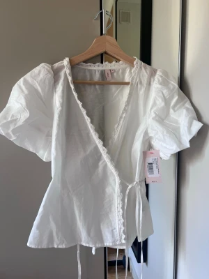 Vit omlottblus - Vit omlottblus med puffärmar från Nelly, helt ny 