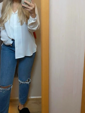 Blå jeans med slitningar från Bikbok - Snygga blå jeans från BikBok i storlek W28 L30. Modellen har slitningar och hål vid knäna.   Tvättade i parfymfritt tvätt- och sköljmedel.  Rökfritt hem🚭
