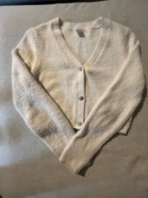 Lindex kofta - Säljer en krämvit lindex kofta i strl 158/164. Den e använd en gång och är i väldigt bra skick. Koftan har ett jätte mjukt fluffigt material och har jätte finna detaljer på knapparna. Rökfritt hem, om du har några frågor skriv gärna!💗🌟