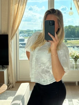 Slutsåld blus från Gina Tricot - Säljer en söt vit blus med puffiga korta ärmar och diskret blommönster i tyget. Har sålts på Gina Tricot för 399 kr, slutsåld 🩷
